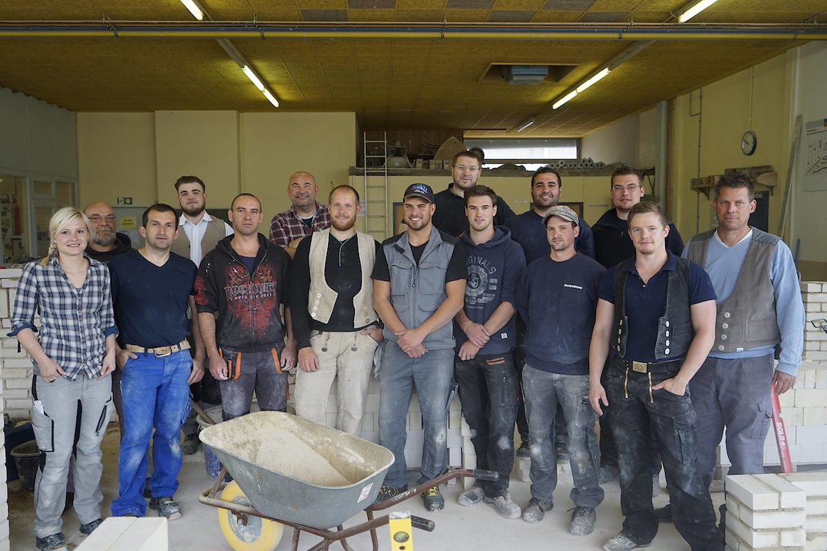 So viele wie schon lange nicht mehr: Lehrgangleiter Marcus Hüls (re.) und sein neuer Kurs der angehenden Maurer- und Betonbauermeister.