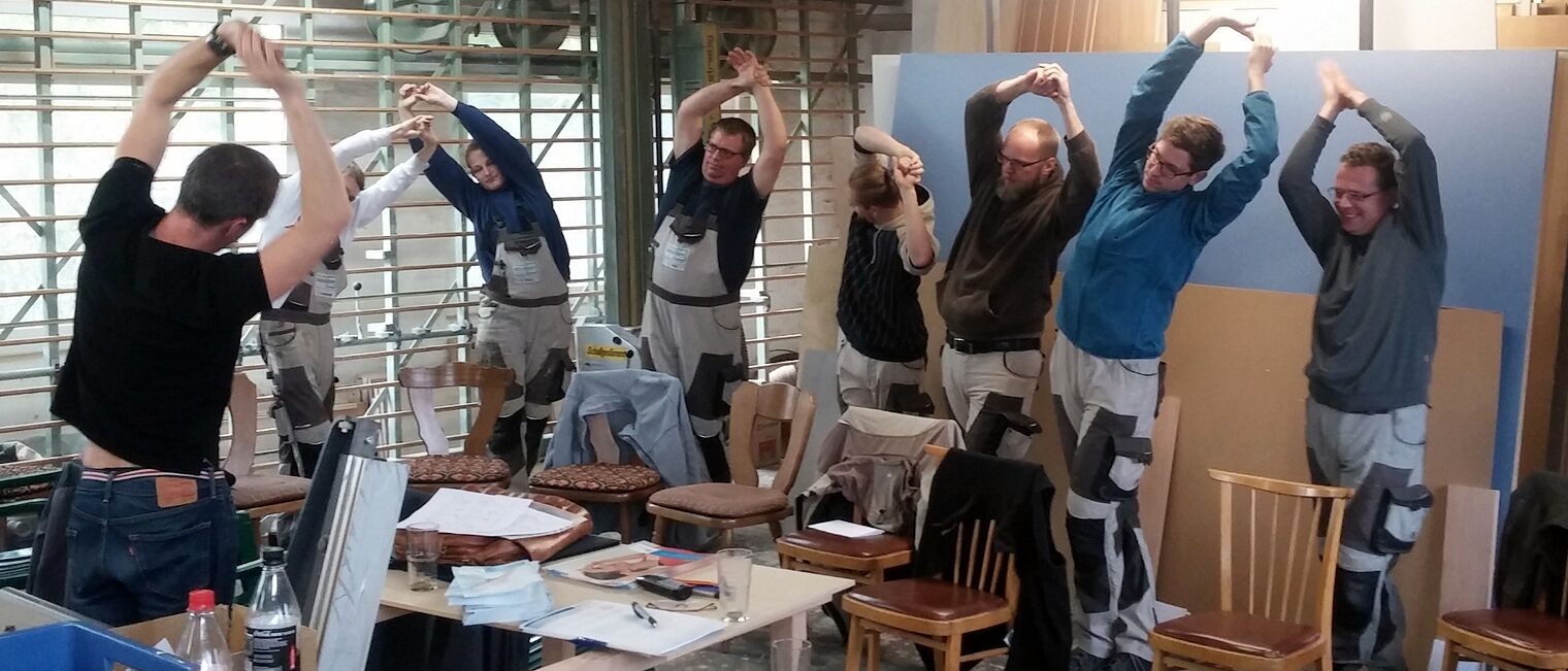 Rückenschule in der Werkstatt: Die Mitarbeiter der Tischlerei Ossenkopp sind gemeinsam für die Gesundheit aktiv.