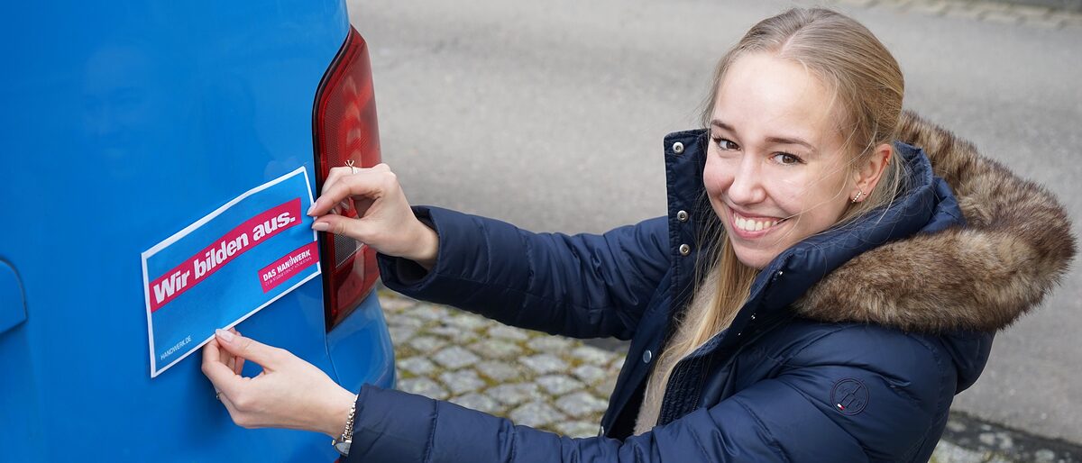 HWK-Mitarbeiterin Helena Griesohn mit den neuen Aufklebern, die Betriebe kostenfrei bei der Handwerkskammer anfragen können HWK-Mitarbeiterin Helena Griesohn mit den neuen Aufklebern, die Betriebe kostenfrei bei der Handwerkskammer anfragen können