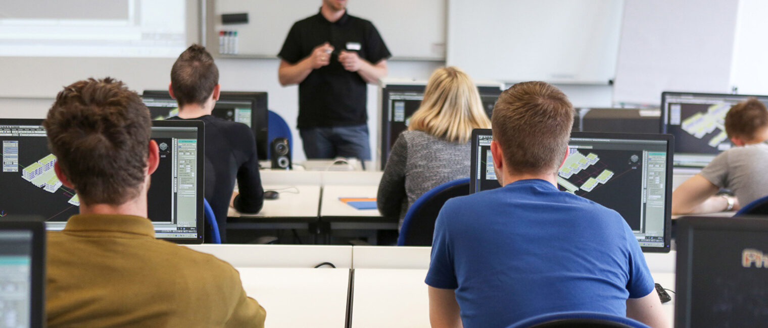 Seminar Teilnehmer hören dem Vortrag zu Ein Ausbilder hält einen Vortrag, während die Auszubildenden Teilnehmer vor Ihrem Computer sitzen und zuhören